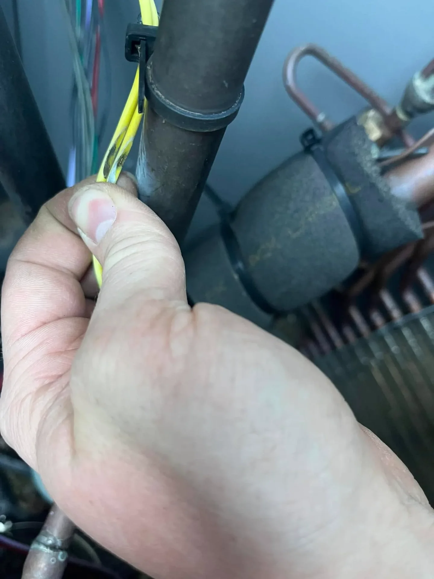 Technician inspecting damaged wiring during emergency HVAC repair